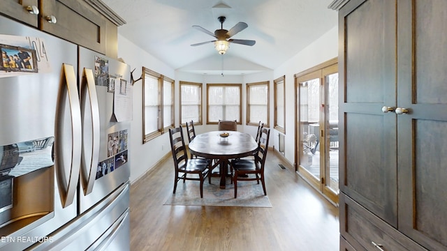 dining space with ceiling fan, lofted ceiling, and light wood-type flooring