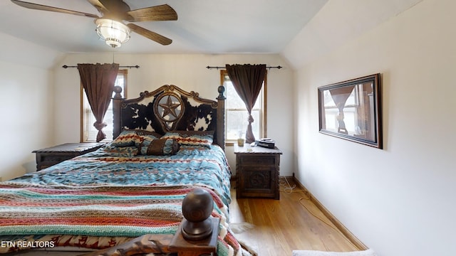 bedroom featuring multiple windows, vaulted ceiling, and ceiling fan