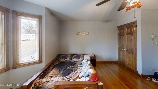 bedroom featuring multiple windows, hardwood / wood-style flooring, and ceiling fan