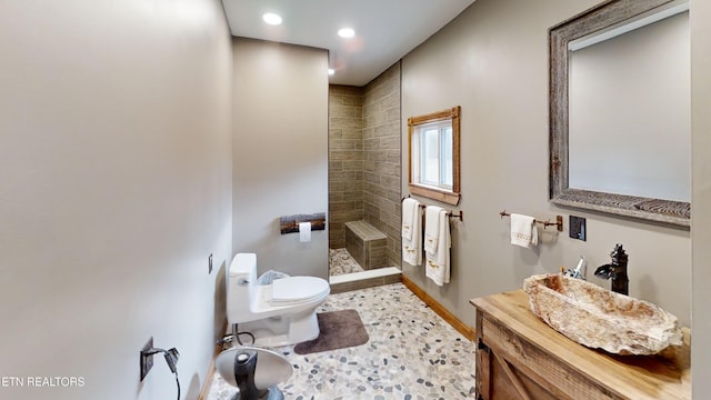 bathroom featuring tiled shower and toilet