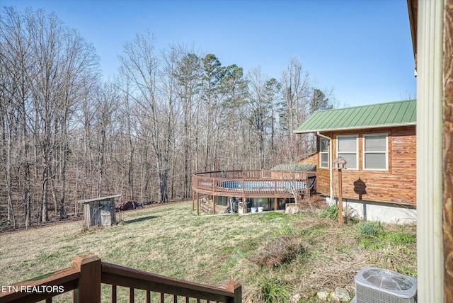 view of yard with a shed, central AC, and a deck