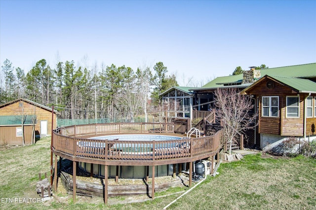 view of pool with a storage unit, a deck, and a lawn