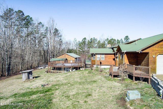 view of yard featuring a garage and a wooden deck