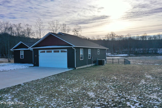 property exterior at dusk with cooling unit and a garage