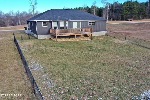 back of property with a wooden deck and a lawn