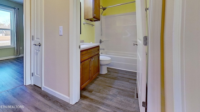 full bathroom with wood-type flooring, toilet,  shower combination, and vanity