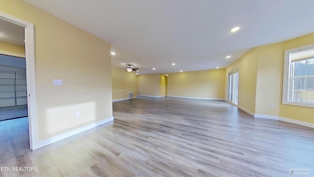 empty room with ceiling fan and light hardwood / wood-style floors