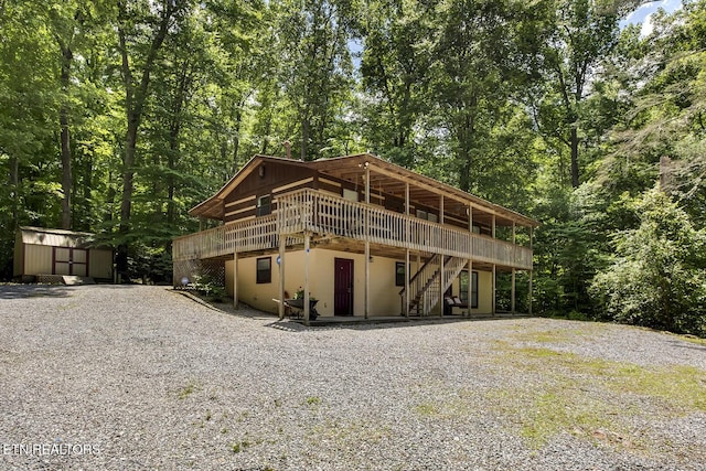 view of front of property with a wooden deck and a shed