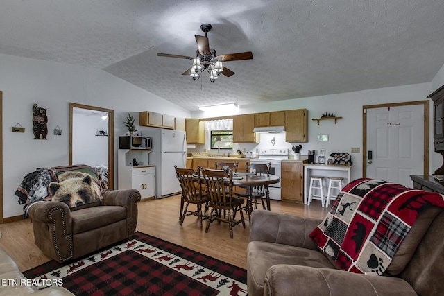 living room with a textured ceiling, sink, vaulted ceiling, ceiling fan, and light hardwood / wood-style flooring