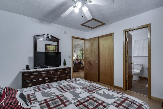 bedroom with a textured ceiling, ensuite bath, wood-type flooring, a closet, and ceiling fan