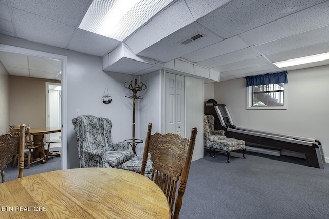 dining area with carpet and a drop ceiling