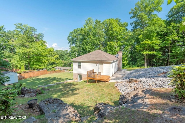 back of property featuring a wooden deck and a lawn