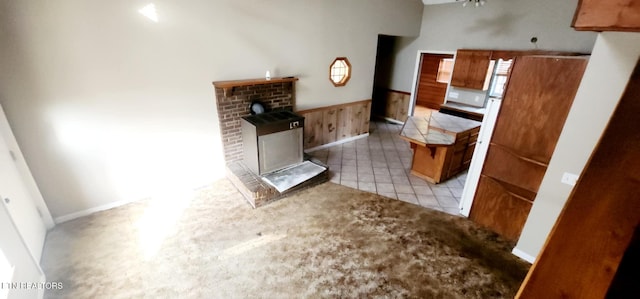 kitchen with ceiling fan, light tile patterned flooring, and wooden walls