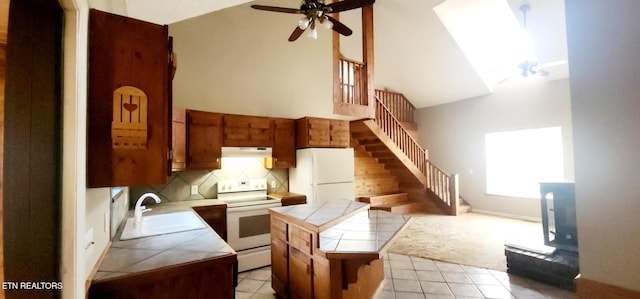 kitchen featuring sink, white appliances, tile countertops, and a kitchen island