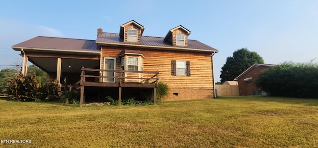 back of house featuring a deck and a lawn