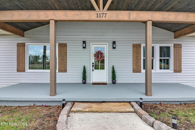 view of exterior entry featuring covered porch