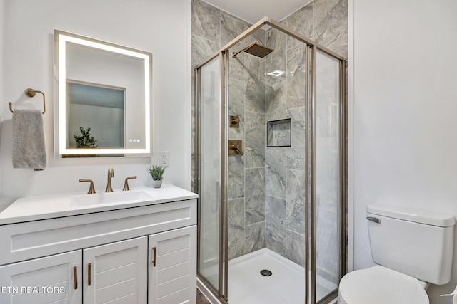 bathroom with toilet, vanity, and an enclosed shower