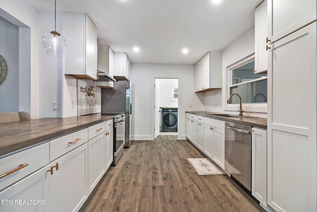 kitchen featuring washer / dryer, sink, appliances with stainless steel finishes, white cabinets, and butcher block counters