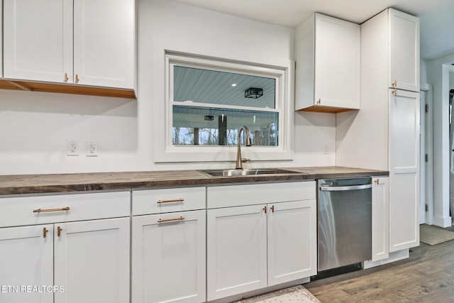 kitchen with sink, white cabinets, stainless steel dishwasher, and wooden counters