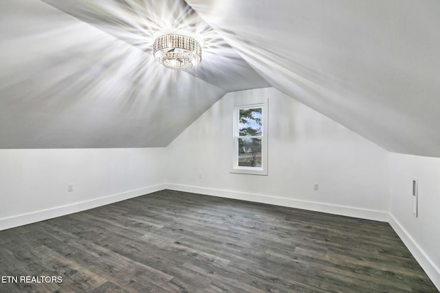 additional living space with vaulted ceiling and dark hardwood / wood-style floors