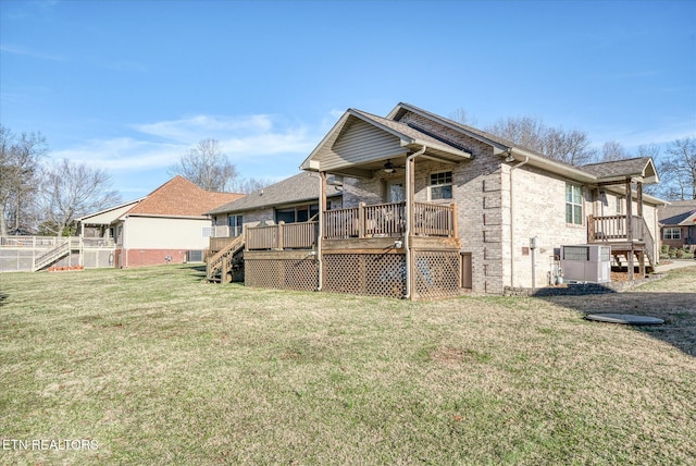 back of house with ceiling fan, brick siding, a yard, stairway, and a wooden deck