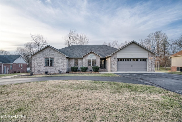 ranch-style home featuring brick siding, a shingled roof, driveway, crawl space, and a front yard