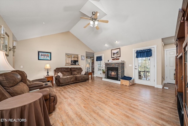 living room featuring a ceiling fan, a stone fireplace, high vaulted ceiling, light wood-type flooring, and baseboards