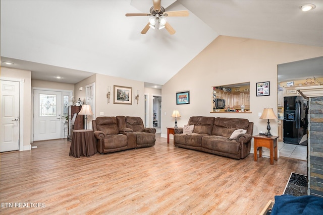 living room with light wood finished floors, baseboards, high vaulted ceiling, and a ceiling fan