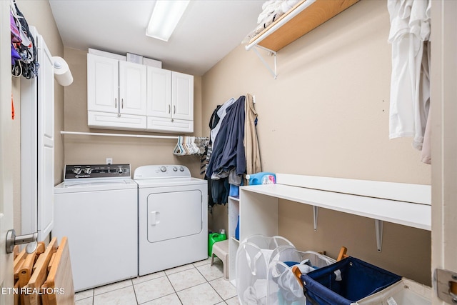 laundry room with cabinet space, light tile patterned floors, and washer and dryer