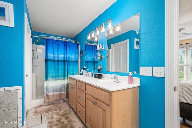 full bath with double vanity, tile patterned flooring, a sink, and a shower with shower curtain