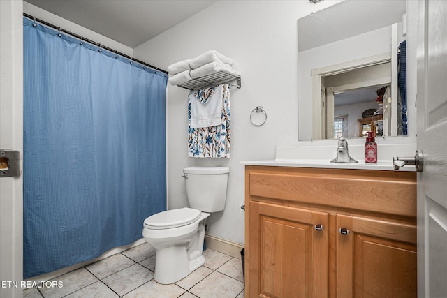 bathroom with baseboards, vanity, toilet, and tile patterned floors