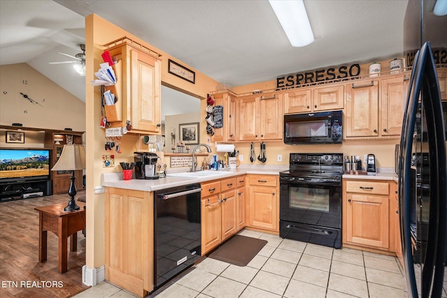 kitchen with light brown cabinets, light countertops, a sink, and black appliances