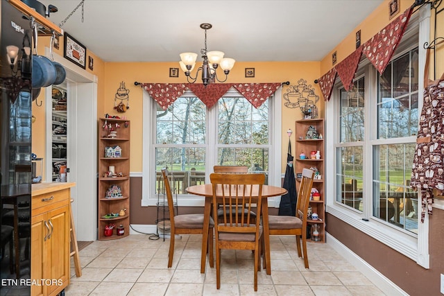 dining room featuring a chandelier, baseboards, and light tile patterned floors