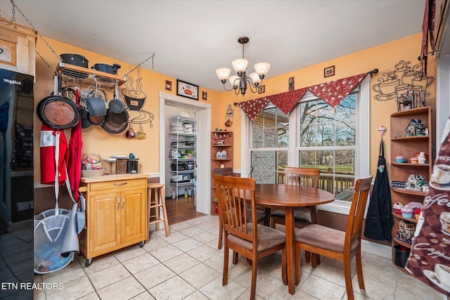 dining room featuring light tile patterned flooring and a notable chandelier