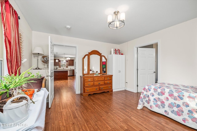 bedroom with a notable chandelier, baseboards, and wood finished floors