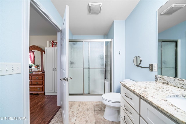 full bathroom with tile patterned flooring, toilet, visible vents, vanity, and a shower stall