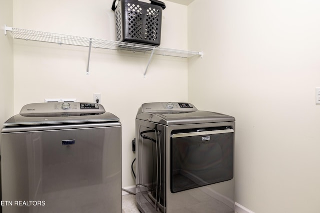 clothes washing area with separate washer and dryer