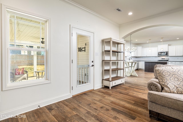 interior space with sink, ceiling fan with notable chandelier, crown molding, and dark hardwood / wood-style floors