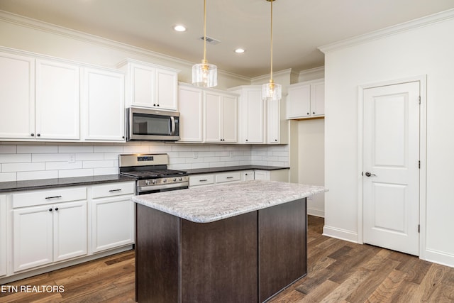 kitchen with stainless steel appliances, white cabinetry, dark wood-type flooring, and decorative light fixtures