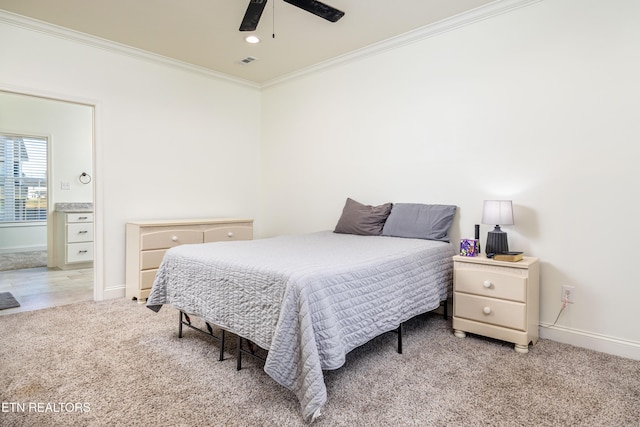 carpeted bedroom with ceiling fan, ornamental molding, and ensuite bath