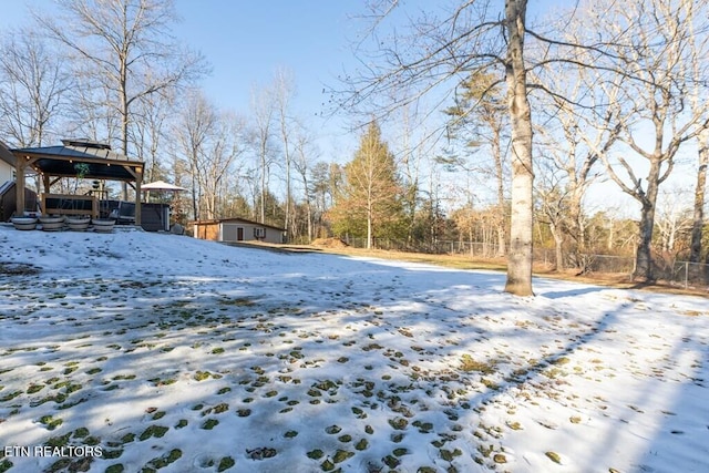 yard covered in snow featuring an outbuilding and a gazebo