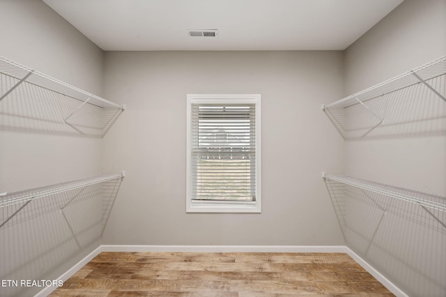 walk in closet with hardwood / wood-style floors