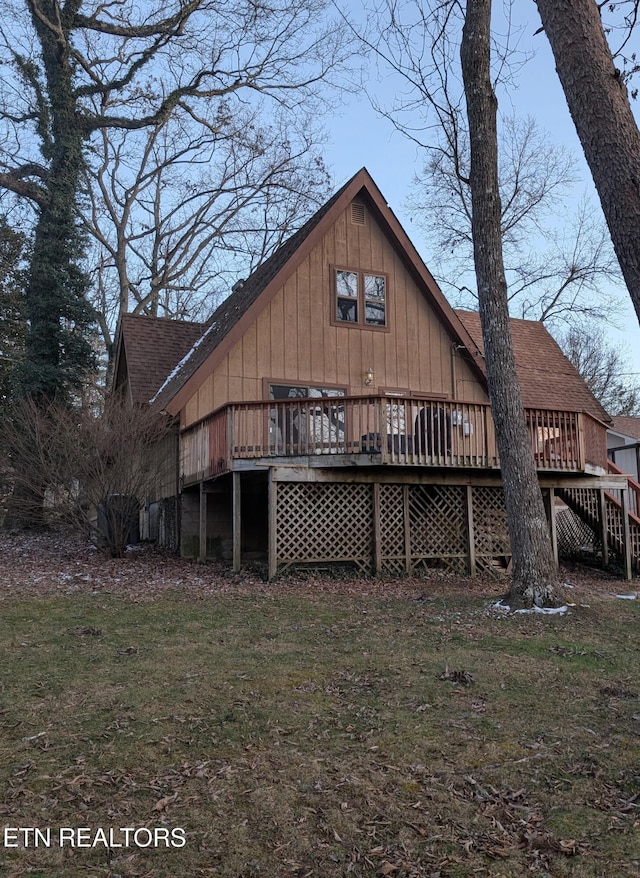 back of property with a yard and a deck