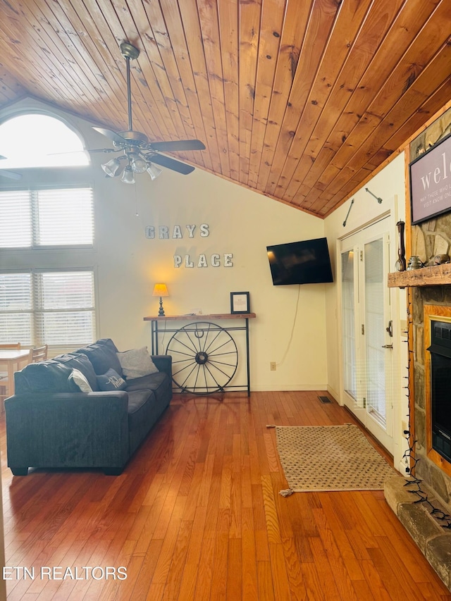 unfurnished living room featuring wood ceiling, a stone fireplace, vaulted ceiling, and hardwood / wood-style flooring