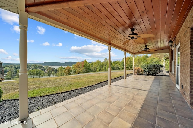 view of patio featuring a water and mountain view and ceiling fan