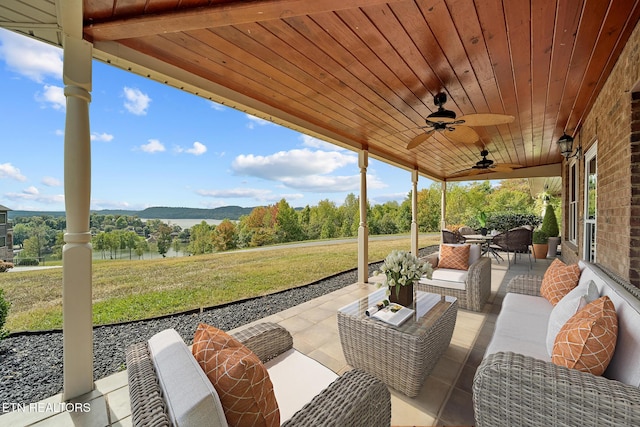 view of patio featuring ceiling fan, a water and mountain view, and outdoor lounge area