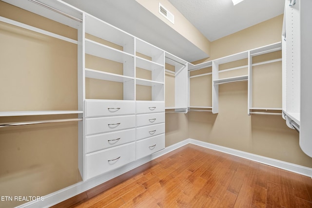 spacious closet with hardwood / wood-style flooring