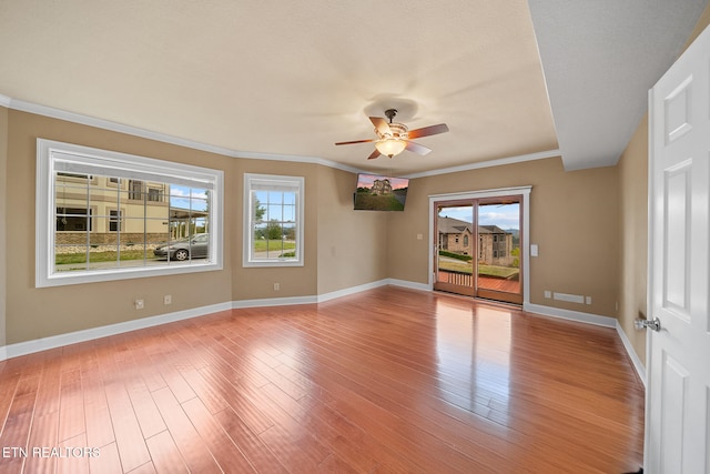 spare room with ceiling fan, ornamental molding, and light wood-type flooring