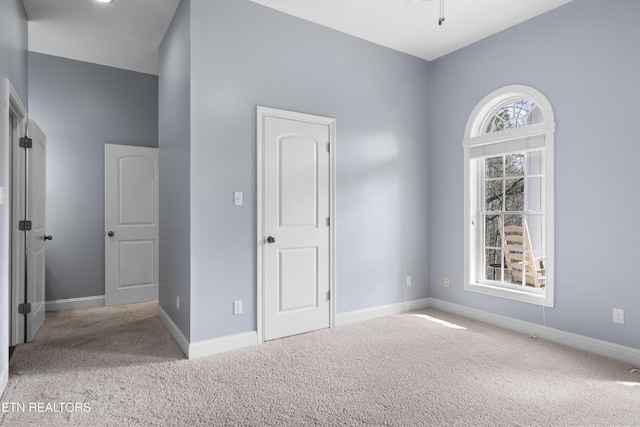 unfurnished bedroom with carpet floors and baseboards