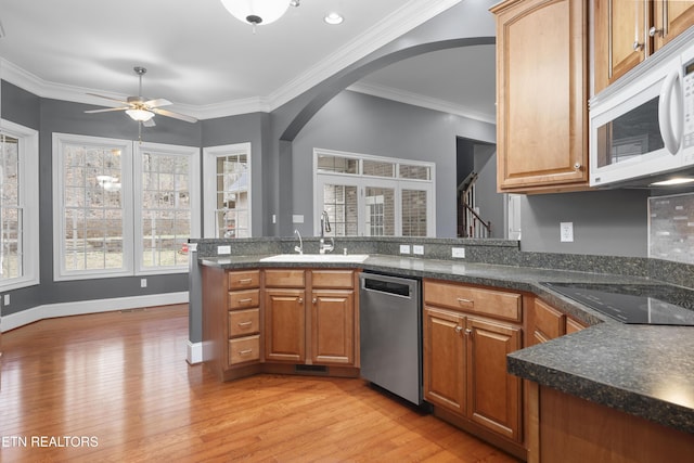kitchen with a sink, light wood-style floors, black electric cooktop, white microwave, and stainless steel dishwasher